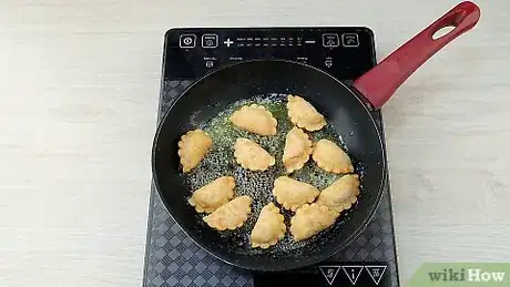 Step 2 将12粒熟的波兰饺子放入锅中。