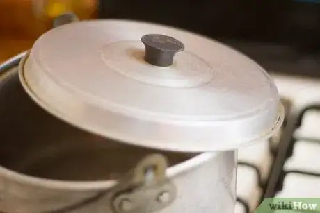 Step 3 如果你要同时煮大量花生的话，就用一个大锅，或者是在炉子上放一个很重的锅。