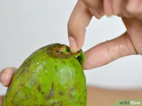 Step 2 捏着鳄梨片的果皮顶端，用食指和大拇指掐进每块楔形鳄梨的顶部，要正好掐在墨绿色果肉的下面，果皮的上面。...