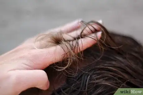 Step 5 用双指夹起分界线上的头发，剪出理想的长度（通常就是手指顶住头部时的厚度）。