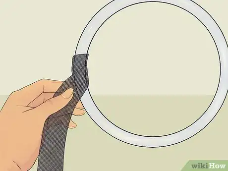 Step 3 把一束黑色的布条扎在花环上。