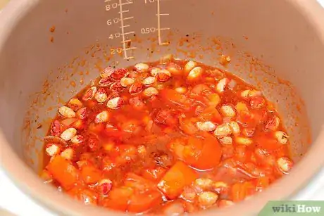 Step 6 把炒好的菜和豆子、月桂叶一起倒进煲汤锅。