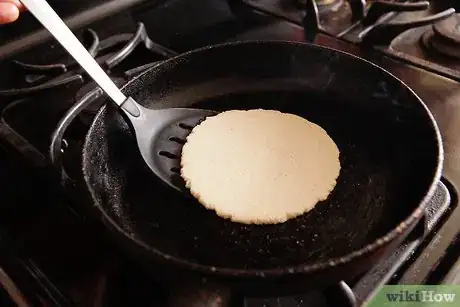 Step 8 在西班牙蛋饼上轻轻地刷一次层油，放在锅上加热。