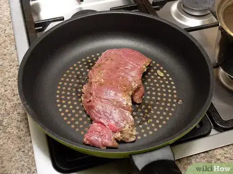 Step 1 用长柄煎锅煎肉。