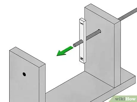Step 6 将金属棒穿过支撑框架的一边，然后将磁铁放置在金属棒上。