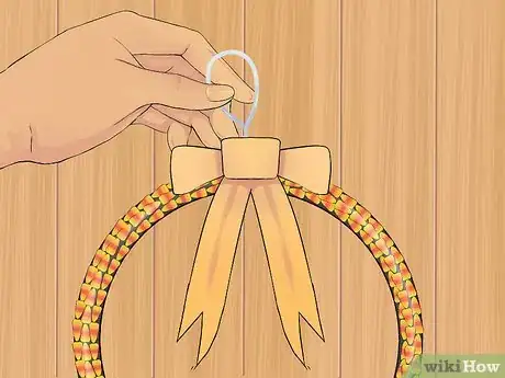 Step 8 将绳子或者可缠绕的东西系在花环的顶部，悬挂在门口。