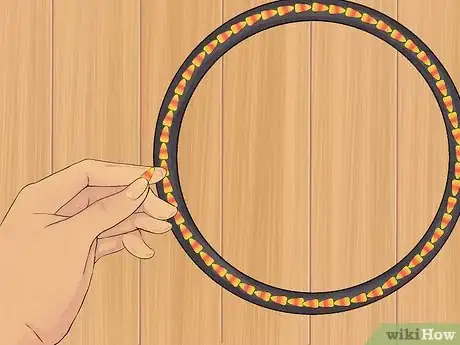 Step 3 加热时粘上一圈糖果玉米，在花环骨架的外边缘。