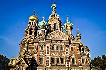 The Russian Revival façade of the Church of the Savior on Blood  is of red brick decorated with mosaics, glazed tiles and architectural ornament, particularly the ogee arches known as kokoshniks.