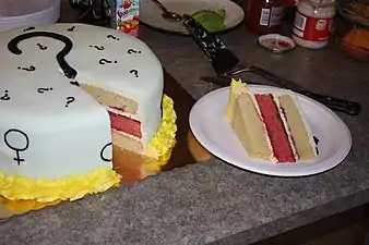 A cake with a pink middle layer indicating a baby girl at a gender reveal party