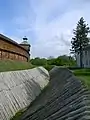 Defensive moat with fortified slopes.