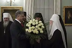 Filaret and Poroshenko, holding a bouquet of white roses