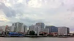 Large modern buildings, seen from a distance over water