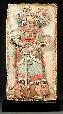 Song wall panel from the tomb of Wang Chuzhi depicting a deity wearing lamellar armoured skirt and winged helmet.