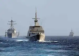 An MH-60S helicopter from USS Freedom approaches RSS Supreme during RIMPAC 2010.