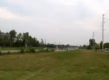 A rural highway with a wide right-of-way vanishes into the distance.