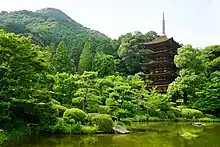 Five-storied wooden pagoda with white walls.