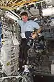 Astronaut Bill McArthur sets up the Space Linear Acceleration Mass Measurement Device (SLAMMD) in the Destiny laboratory during Expedition 12. The SLAMMD guiding arm, leg restraint, and head rest are attached to the Human Research Facility 1 (HRF-1). - NASA Image: ISS012E12597