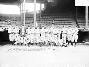 Two rows of men wearing white old-style baseball uniforms with large block "P"s over the left breast and old-style crownless baseball caps