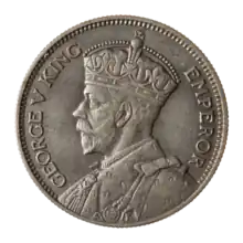 A crowned portrait of George V in royal dress, with the encircling text GEORGE V KING to the left, and EMPEROR to the right.