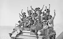 Soldiers sitting on an armoured personnel carrier