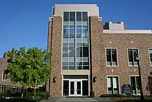 A four-story brick and stone building alongside pedestrian path