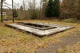 Une surface bétonnée avec une petite fosse à l’emplacement du treuil.