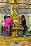 People pouring Buddha statue