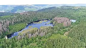 Aerial view of a large pond on a wooded ridge