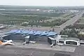 An aerial view of NQZ International Terminal 1 in July 2021 including the Astana Light Metro visible in the background