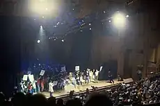 A crowd of people on a stage holding signs