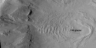 Glacier on a crater floor, as seen by HiRISE under HiWish program  The cracks in the glacier may be crevasses.  There is also a gully system on the crater wall.