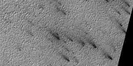 Close view of defrosting, as seen by HiRISE under HiWish program Gas and dark dust is probably being blown out of ground and then carried by winds toward the Northwest.