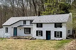 Stuccoed stone house with Colonial Revival embellishment