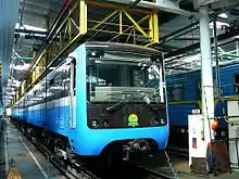 Blue mass-transit train pulling into a station