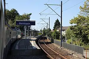 Train pulls in to station with single island platform