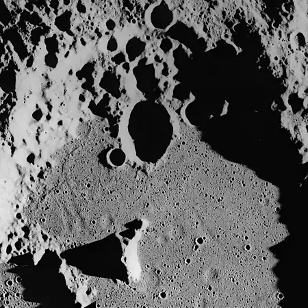 Ghost craters on the surface of the Cayley Formation in the bottom of Albategnius crater. Albategnius B crater (above center) is approximately 15 km across. Subdued troughs trending north-northwest may be buried Imbrium sculpture. The Cayley Formation may be mantling fresh craters to produce a subdued flatbottomed bowl shape.