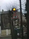 A traffic signal ahead sign in France. (the light flashes to indicate a red light ahead)