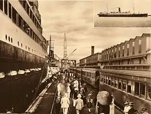 Passenger train on pier with cruise ship