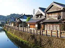 A small street and wooden houses next to a canal.