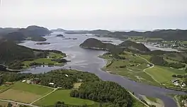 A downstream view of a fjord with cabins and hills