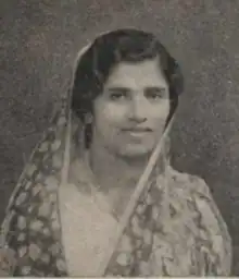 A South Asian woman with dark wavy hair, head covered by a light patterned dupatta