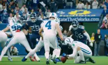 Vinatieri walking up to the kicker, shot from behind