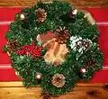 Advent wreath with one rose candle and three purple candles, all lit