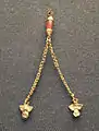 Gold ornament with two chains ending in owl figurines