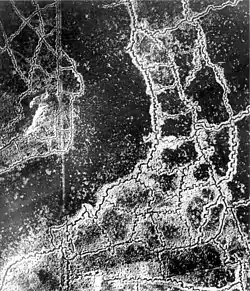 An aerial reconnaissance photograph of the opposing trenches and no man's land between Loos and Hulluch in Artois, France. German trenches are at the right and bottom, and British trenches are at the top left. The vertical line to the left of centre indicates the course of a pre-war road or track.