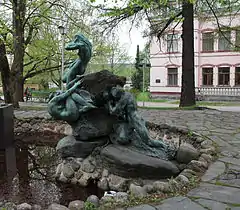 The fountain from the side (Aino is attempting to resist the call of the three water maidens of Vellamo, while a man of Ahtola is pushing the rock from behind)