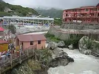 image of Alaknanda river with a hanging bridge across it