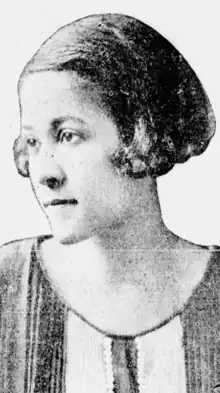 A young Black woman with hair cut in a short bob, wearing a striped top with a scoop neckline