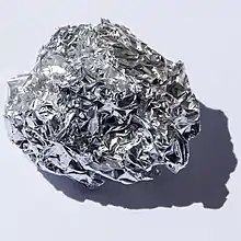 A ball of aluminium foil over a white background