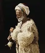 Hand-coloured photography example from the American Colony, peasant spinning wool in Ramallah (1919).Source: Library of Congress